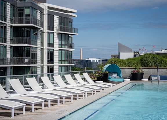 Beautiful pool with sun loungers in front of a building. at Dock 79, Washington, 20003