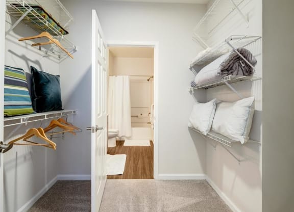 a closet with shelves and pillows and a door to a bathroom at Lincoln Old Town, Alexandria