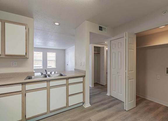 A kitchen with a sink and a white door at West Park Apartments, Albuquerque