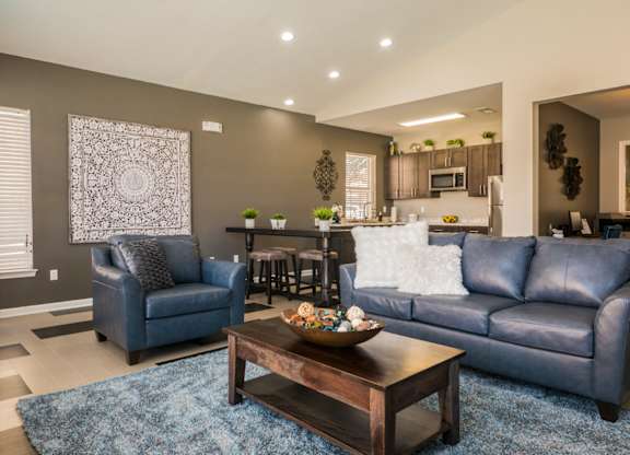 A living room with a blue couch and a coffee table at West Park Apartments, New Mexico