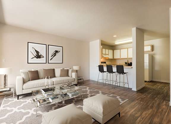 A modern living room with a white couch, a glass coffee table, and a rug with a geometric pattern at West Park Apartments, Albuquerque, NM