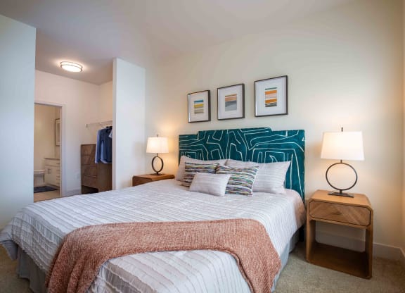a bedroom with a bed and pictures on the wall at Woodmore Grand, Bowie