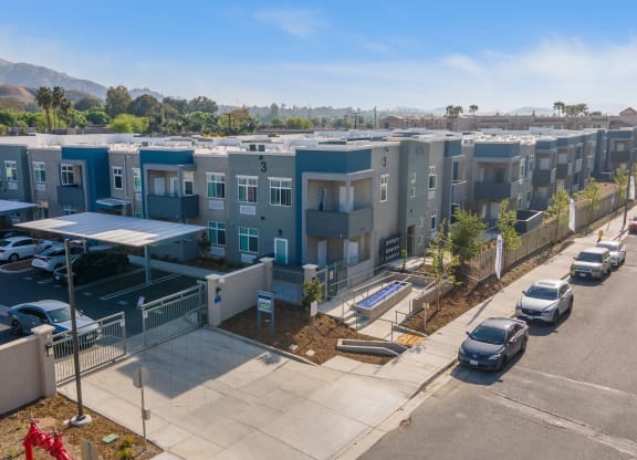 a row of apartment buildings with cars parked in front of them at Loma Villas Apartments, San Bernardino California