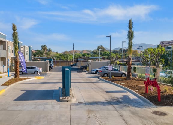a parking lot at the whispering winds apartments in pearland, tx at Loma Villas Apartments, San Bernardino California