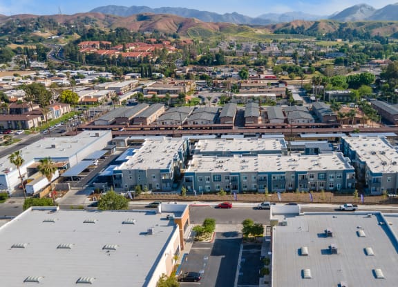 an aerial view of a large industrial park with rows of buildings and hills in the background at Loma Villas Apartments, San Bernardino