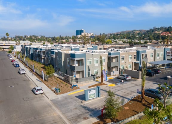 a row of apartment buildings with cars parked in front of them at Loma Villas Apartments, San Bernardino, 92408
