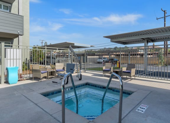 a pool with a fence around it at the whispering winds apartments in pearland, tx at Loma Villas Apartments, San Bernardino, 92408