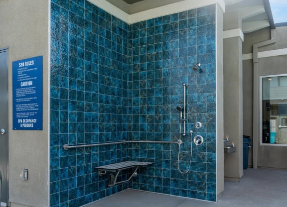 a blue tiled shower stall in a public restroom at Loma Villas Apartments, California, 92408