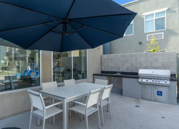 a patio with a table and chairs and a grill at Loma Villas Apartments, San Bernardino California