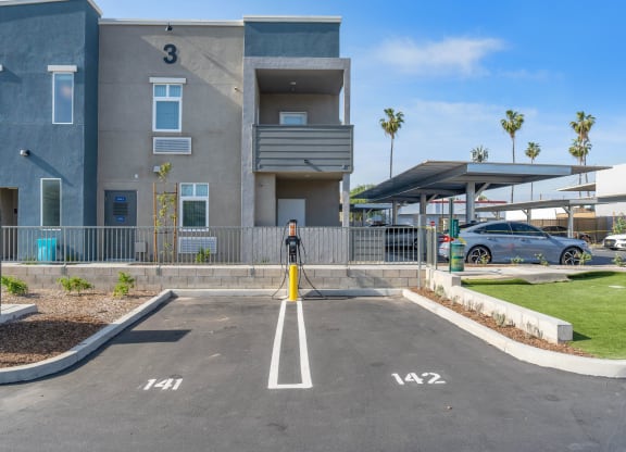 a parking lot at the whispering winds apartments in pearland, tx at Loma Villas Apartments, San Bernardino, CA