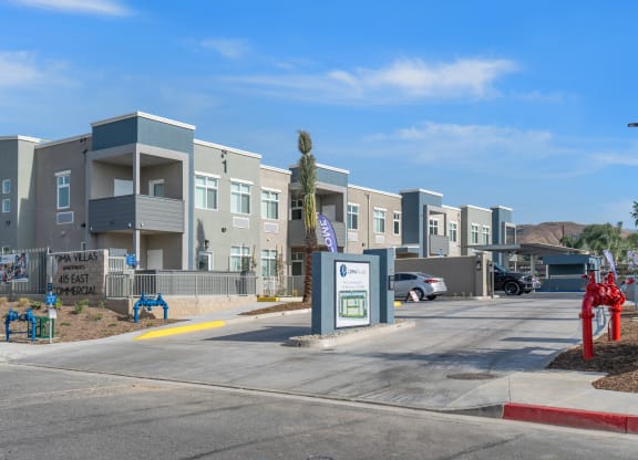 a row of apartment buildings with a parking lot in the foreground at Loma Villas Apartments, San Bernardino, 92408