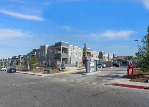a row of apartment buildings with cars parked in front of them at Loma Villas Apartments, San Bernardino, 92408