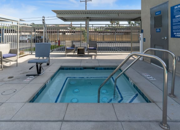 a hot tub with a metal railing in front of a building at Loma Villas Apartments, San Bernardino
