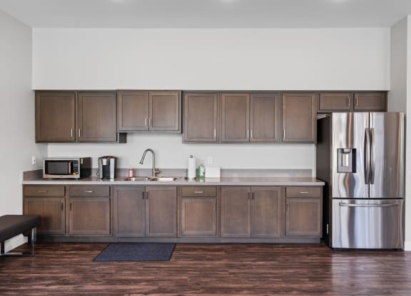 a kitchen with wooden cabinets and a stainless steel refrigerator at Loma Villas Apartments, California, 92408