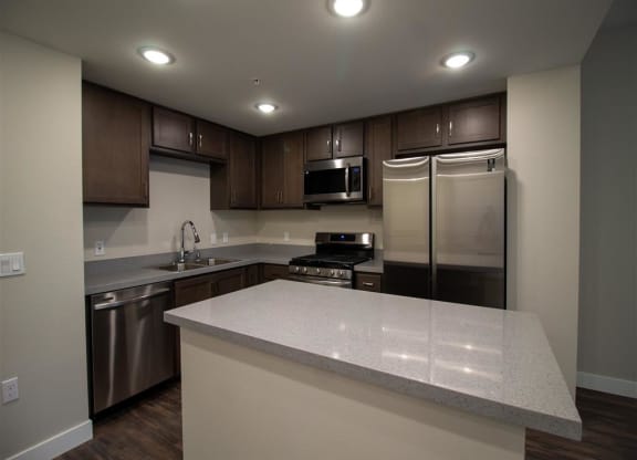 a kitchen with a large island and stainless steel appliances at Loma Villas Apartments in San Bernardino, CA