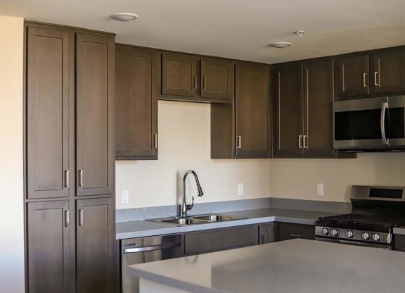 kitchen with a sink a stove and a microwave at Loma Villas Apartments, California