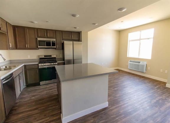 kitchen and living room with a large window at Loma Villas Apartments in San Bernardino, CA