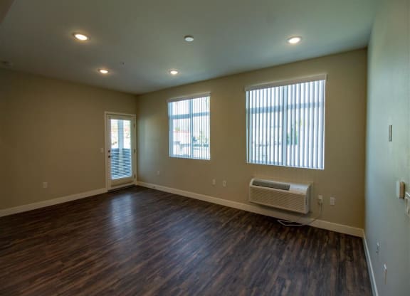living room with hardwood floors and three windows at Loma Villas Apartments, San Bernardino, CA