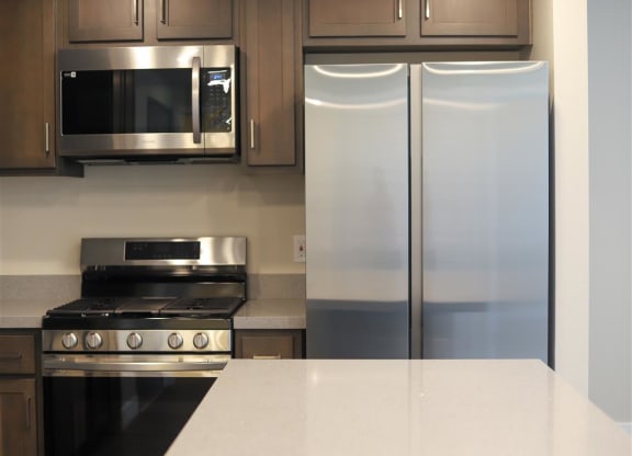 a kitchen with a stove microwave and refrigerator at Loma Villas Apartments, San Bernardino, 92408