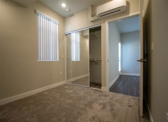 a bedroom with a closet and a window at Loma Villas Apartments, California, 92408