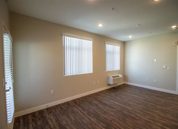 an room with two windows and a radiator at Loma Villas Apartments in San Bernardino, CA