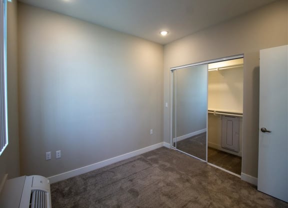 a room with a carpeted floor and a door to a bathroom at Loma Villas Apartments in San Bernardino, CA