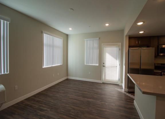 an empty living room with a kitchen in the background at Loma Villas Apartments, San Bernardino, 92408