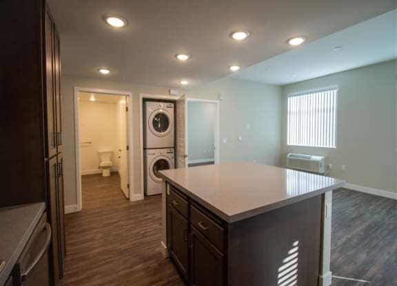 a kitchen with an island and a washer and dryer at Loma Villas Apartments, San Bernardino, CA