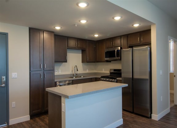 kitchen with dark wood cabinets and a white counter top at Loma Villas Apartments in San Bernardino, CA