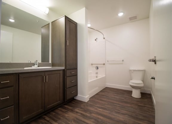 a bathroom with a toilet sink and mirror at Loma Villas Apartments, California, 92408