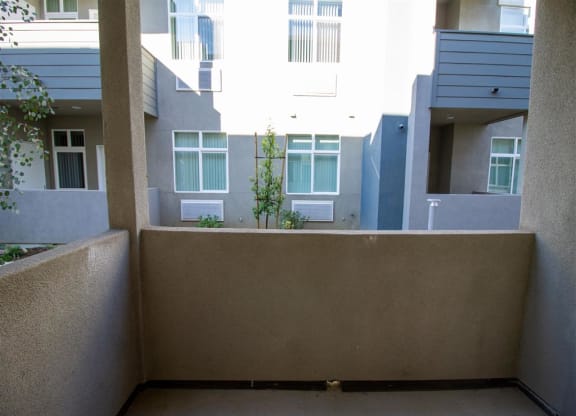 an empty balcony with an apartment building in the background at Loma Villas Apartments, San Bernardino California at Loma Villas Apartments, San Bernardino