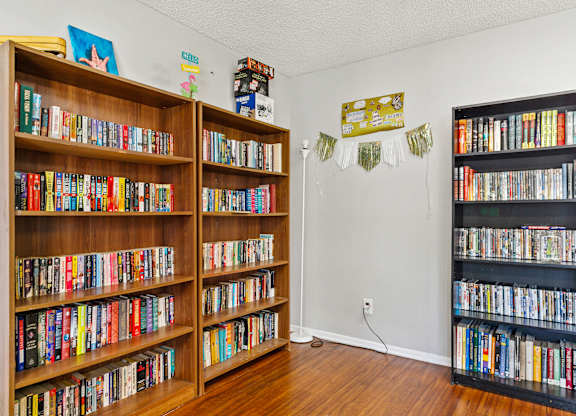 A room with a bookshelf filled with books on the left and right side. at Canyon Shadows Apartments, California