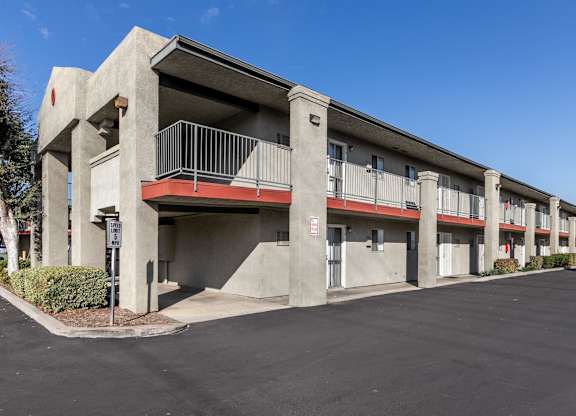 A concrete building with a red balcony. at Canyon Shadows Apartments, Riverside