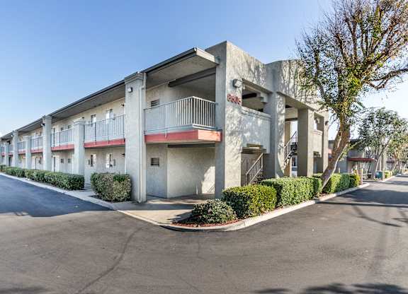 A street view of a residential building with a clear blue sky. at Canyon Shadows Apartments, California