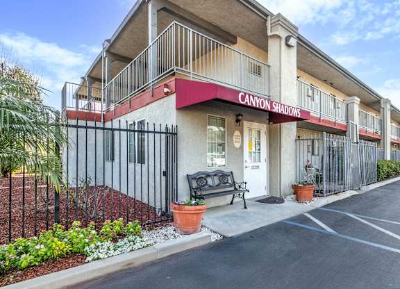 The image shows a building with the name CANYON SHADOWS on it. at Canyon Shadows Apartments, Riverside