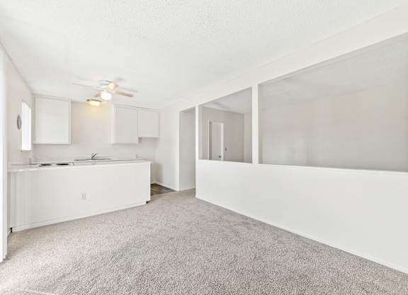A white kitchen with a fan on the ceiling. at Canyon Shadows Apartments, California 