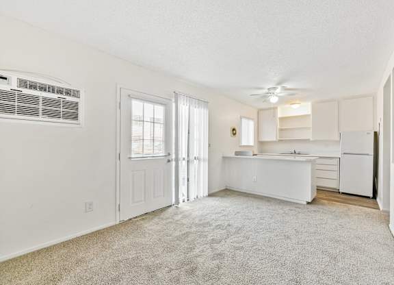 A white kitchen with a refrigerator, sink, and cabinets. at Canyon Shadows Apartments, Riverside, CA 92503 