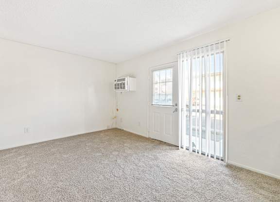 A room with a window, carpet, and a door. at Canyon Shadows Apartments, California, 92503