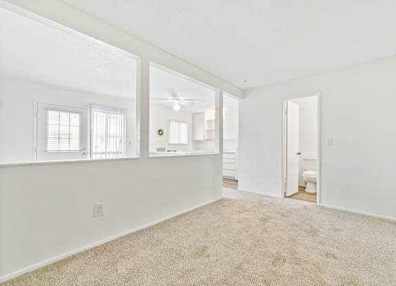 A spacious room with a carpeted floor and a doorway leading to another room. at Canyon Shadows Apartments, California, 92503