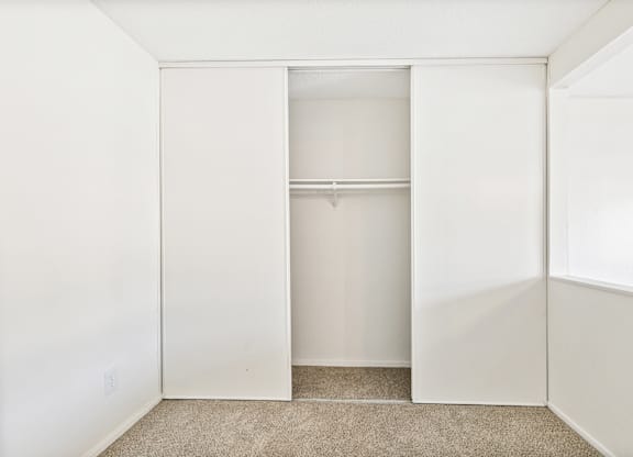 A white closet with a carpeted floor and a shelf. at Canyon Shadows Apartments, California 