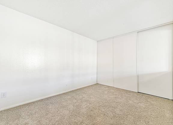 A room with a carpeted floor and white walls. at Canyon Shadows Apartments, Riverside California 