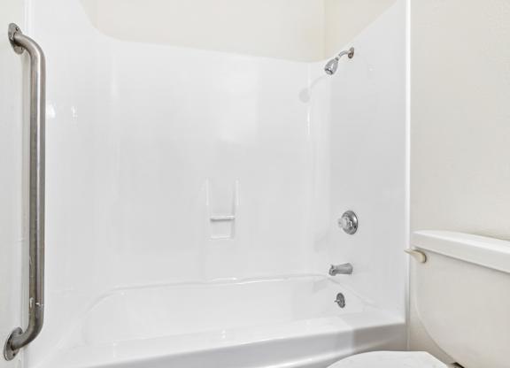 A white bathtub with a silver grab bar on the side. at Canyon Shadows Apartments, Riverside, 92503