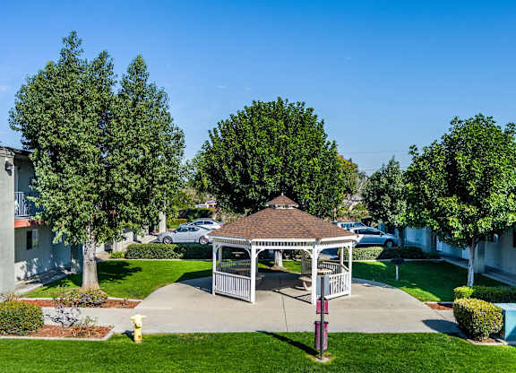 A gazebo is in the middle of a grassy area. at Canyon Shadows Apartments, Riverside, 92503  