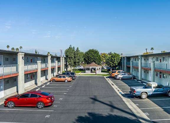 A parking lot with cars and apartment buildings. at Canyon Shadows Apartments, Riverside California 