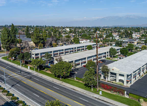 A large building with a grey roof is situated on a street corner. at Canyon Shadows Apartments, California, 92503