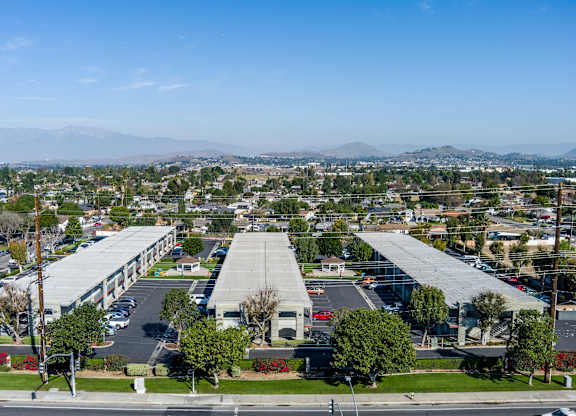 A large building complex with a parking lot in front. at Canyon Shadows Apartments, Riverside, CA 92503