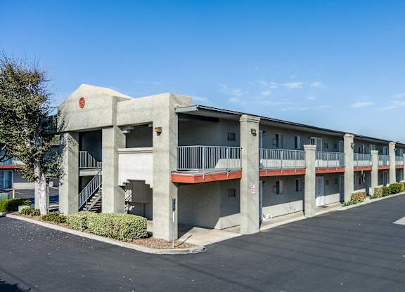 A concrete building with a red circle on the top left corner. at Canyon Shadows Apartments, California, 92503