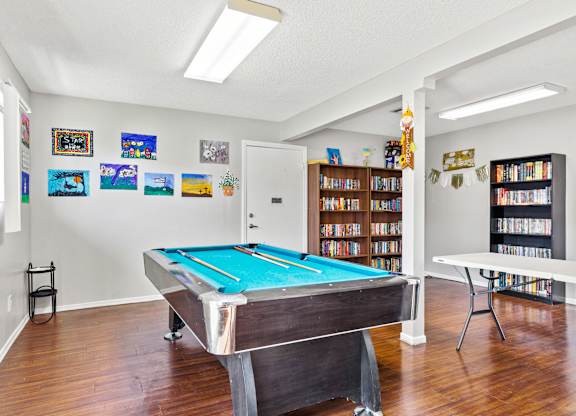 A room with a pool table and a bookshelf. at Canyon Shadows Apartments, Riverside, CA 92503