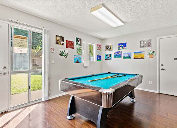 A pool table in a room with pictures on the wall. at Canyon Shadows Apartments, California
