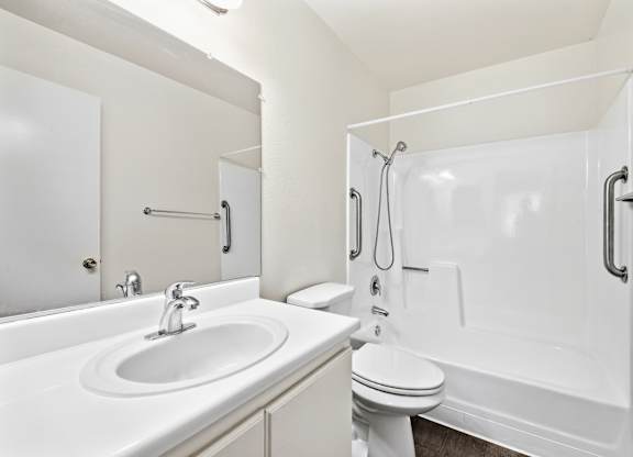 A white bathroom with a sink, toilet, and bathtub. at Heritage Park, Rialto, CA 92376